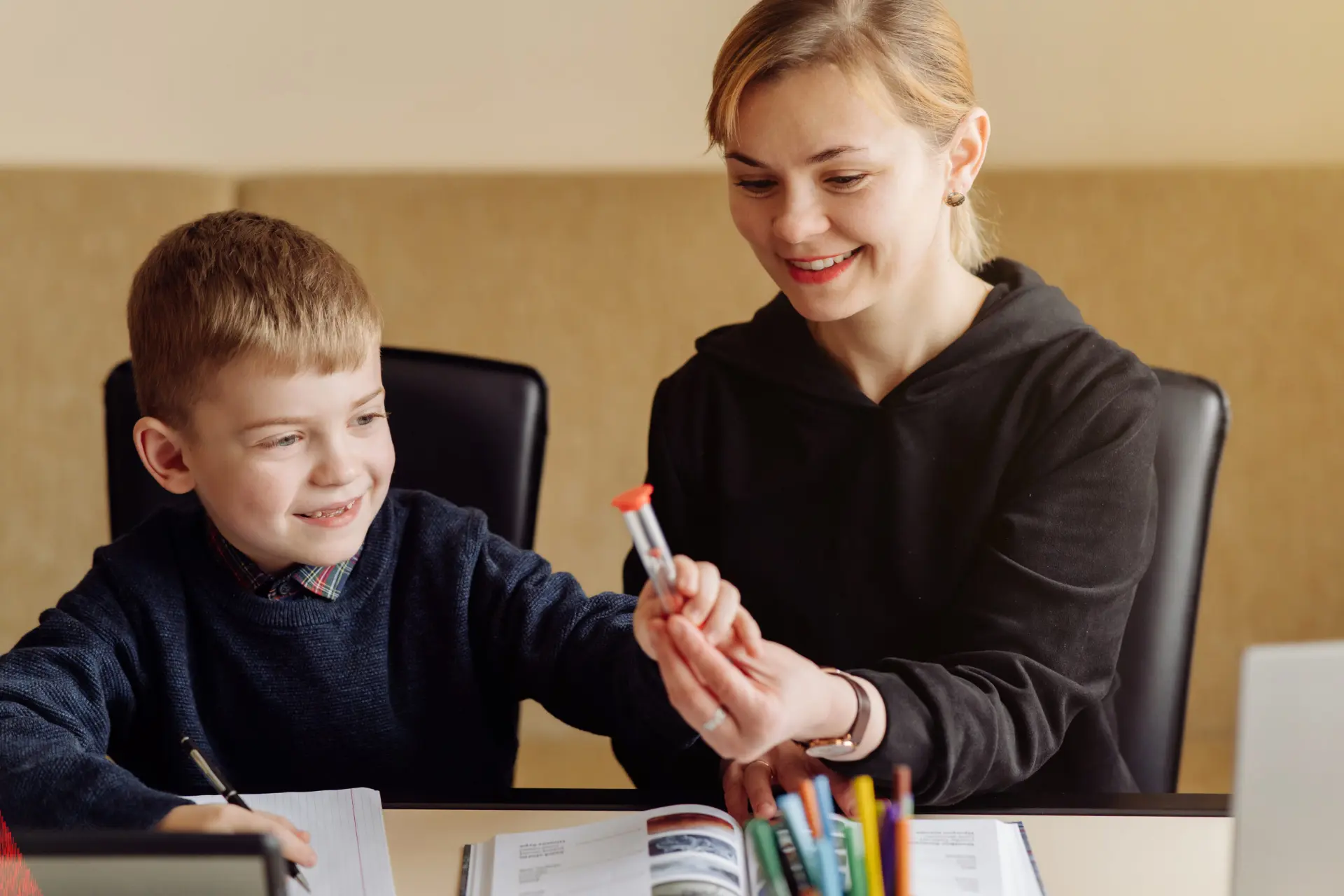 Teaching assistant reading with a primary school pupil