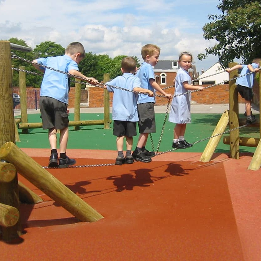 Primary school pupils playing together in a sunny school playground