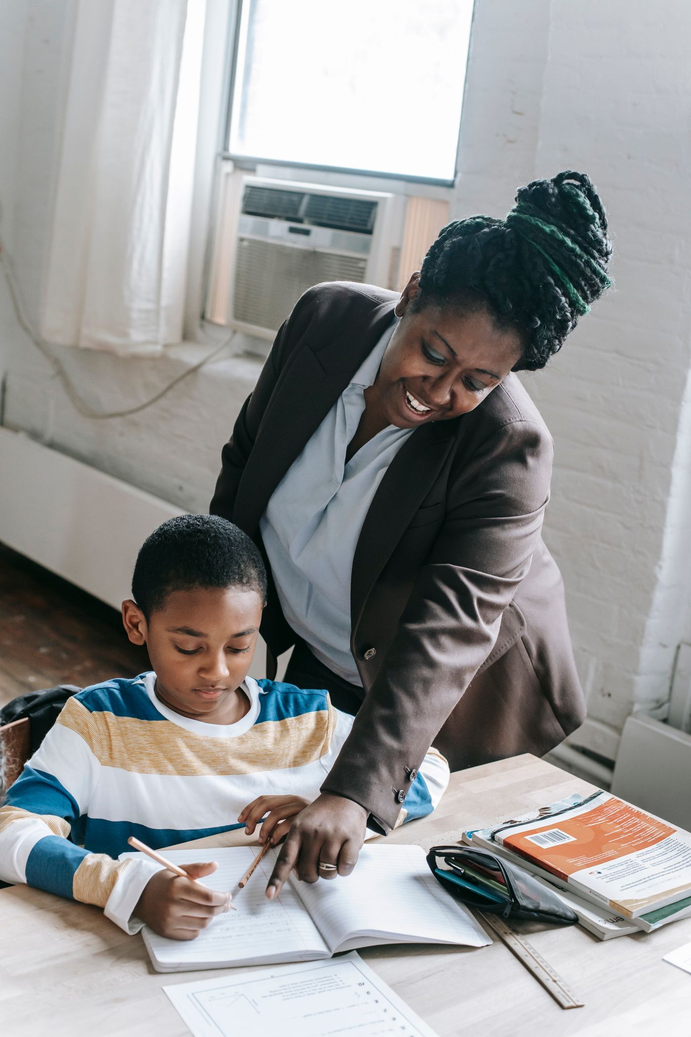 Teaching assistant giving one-to-one support to a pupil in a SEND classroom